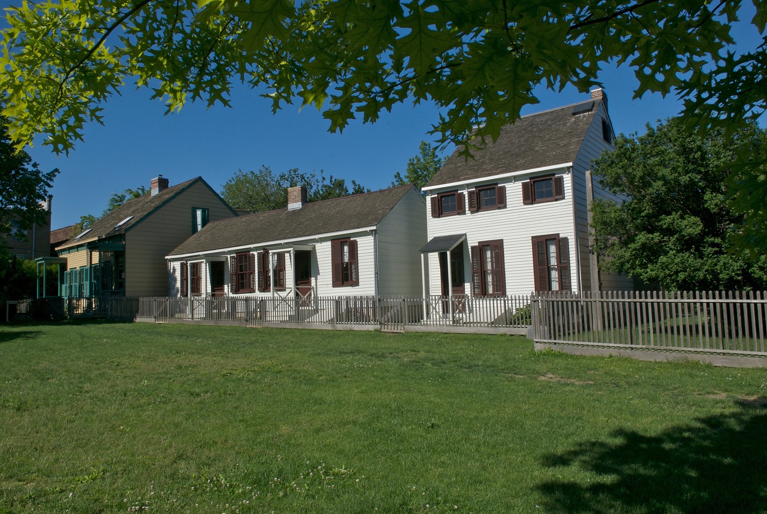 The exterior of the Weeksville houses with a green lawn in foreground