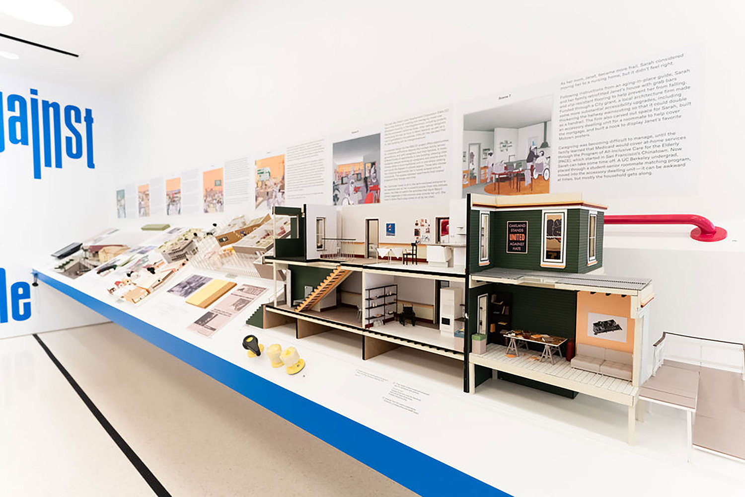 Long angled shelf with architectural models and images installed on it