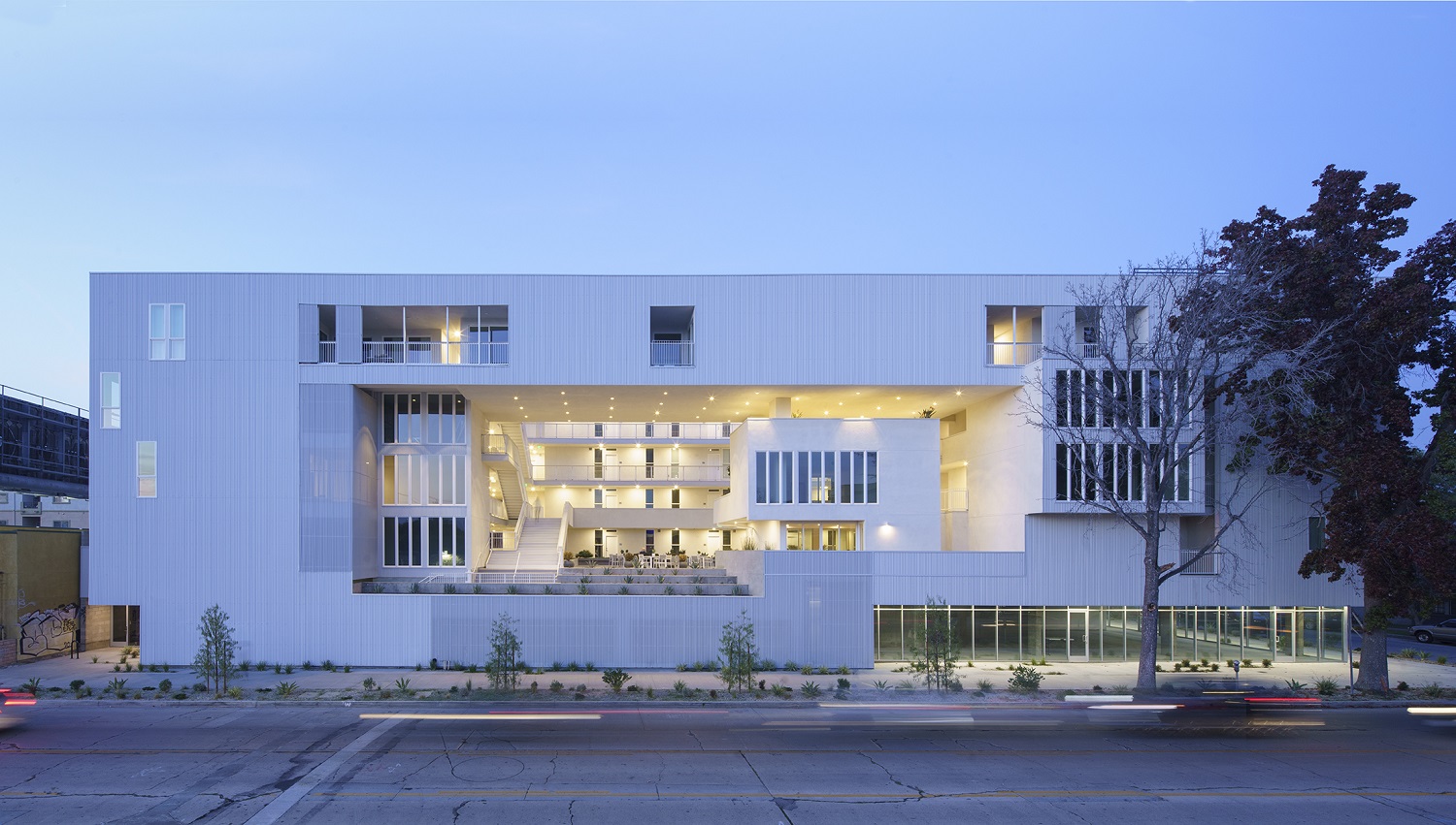 Photo of the white, front facade of 11 NOHO, an affordable housing complex in Los Angeles