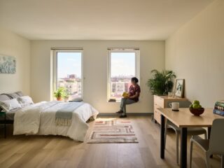 A woman seated at a window in the Betances Residences