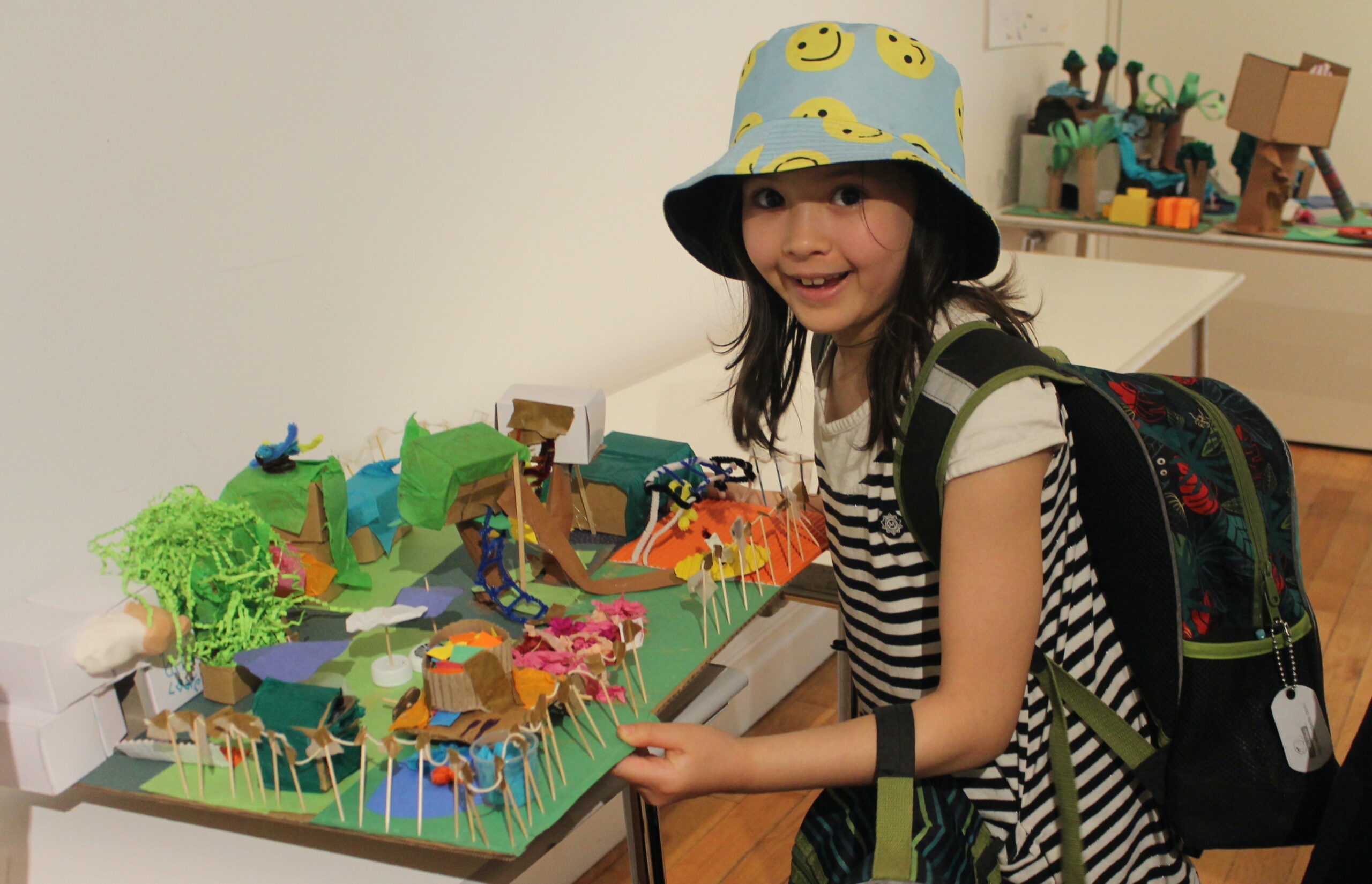 Elementary school student posing with their model of a park and playground