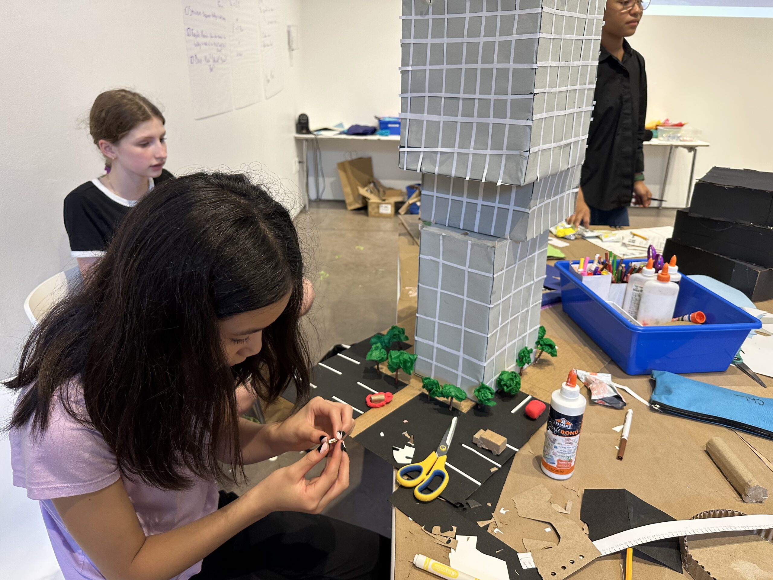 Middle school student working on a tall skyscraper model