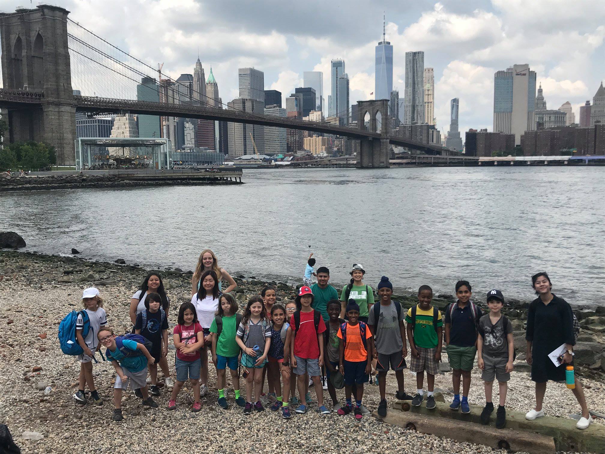 Class of elementary school students on the waterfront in Brooklyn with Brooklyn Bridge in the background