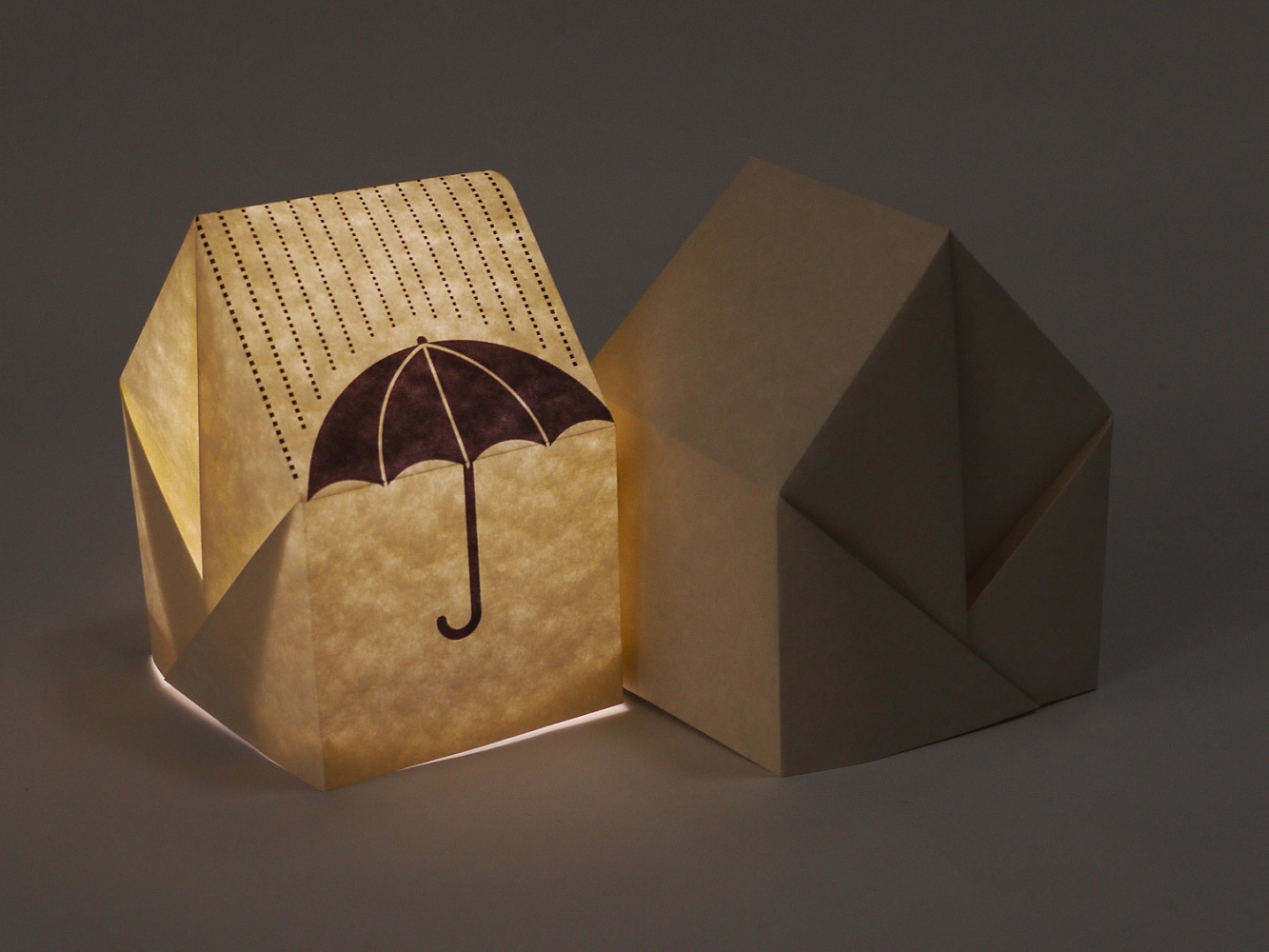 Photo of an origami paper house with an umbrella print.