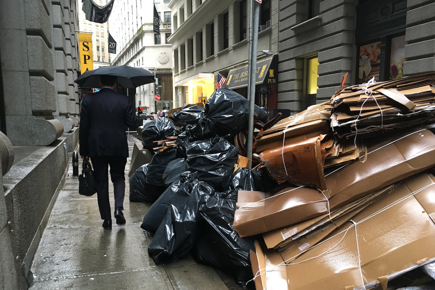 Image of umbrella Man with Trash bags