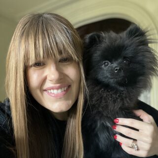 Portrait of Elaine Santos holding her dog