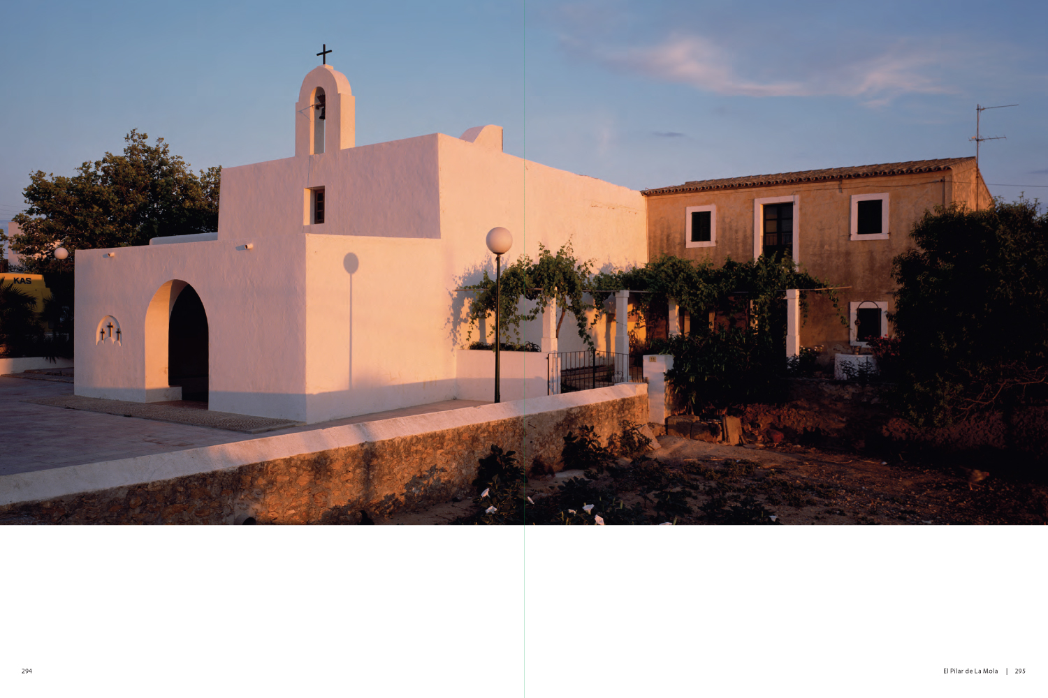 Two story white stucco church with trees in front