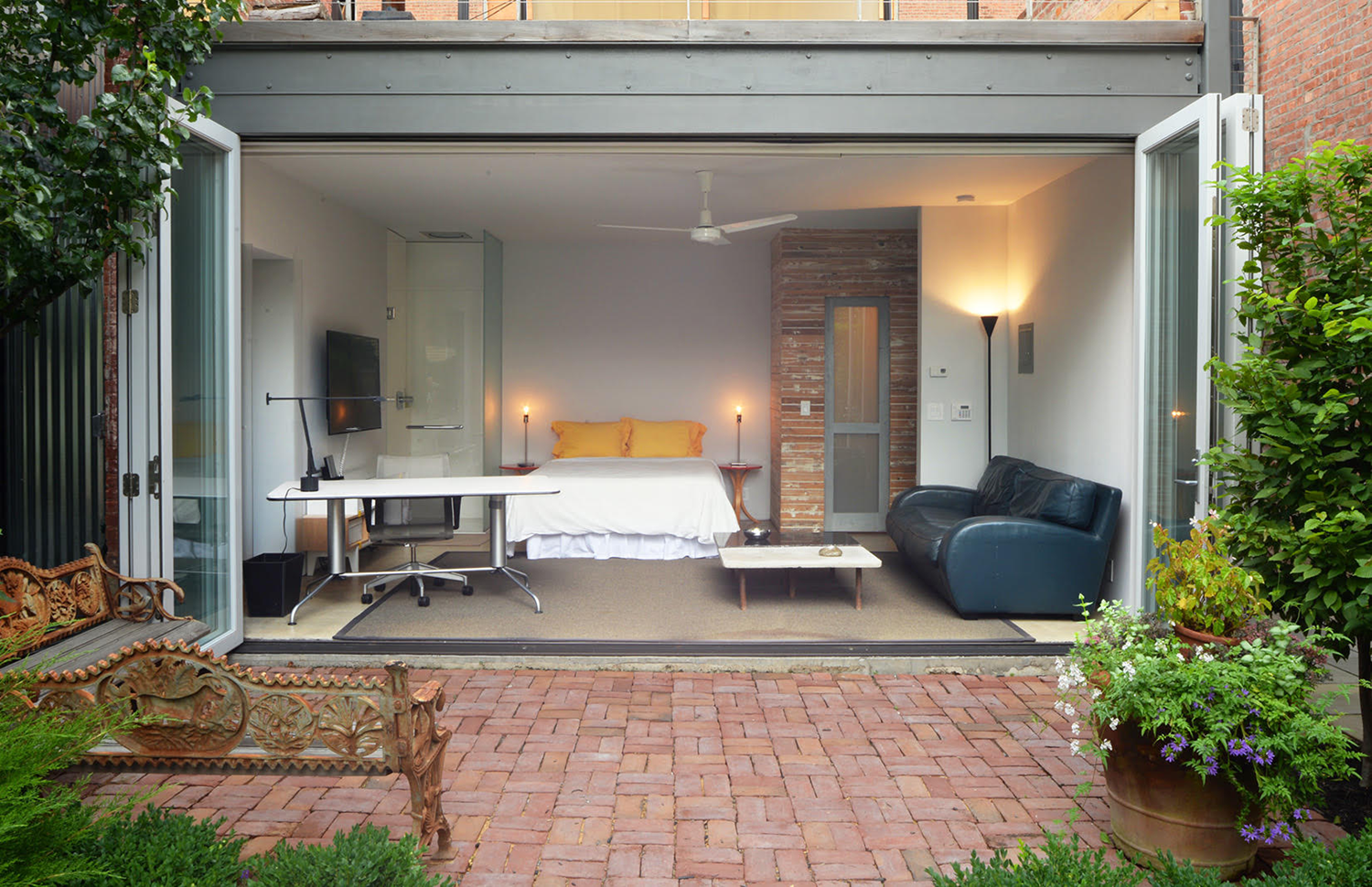 Image of a open plan bedroom leading to a courtyard